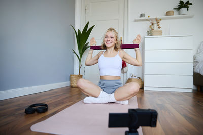 Full length of young woman sitting on table