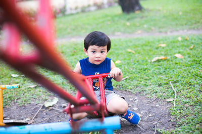 Portrait of cute baby boy sitting on seesaw