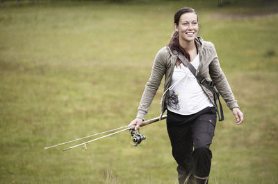 Young woman walking with casting rod