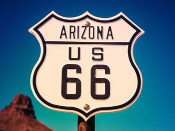 Close-up of arizona 66 sign with number 66 against clear sky