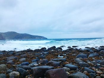 Rocks on beach against sky