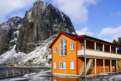 House on snowcapped mountain against sky