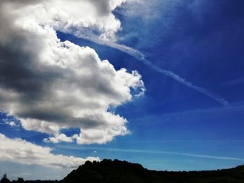 Low angle view of vapor trail against blue sky