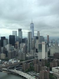 Skyscrapers in city against cloudy sky