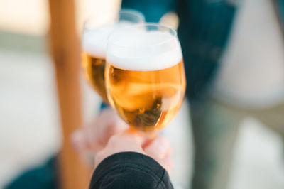Close-up of hand holding beer glass