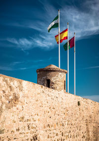 Low angle view of flag on built structure against sky