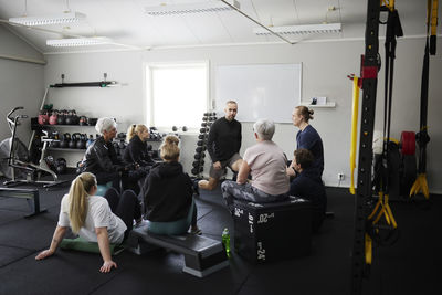 Smiling people exercising together in gym