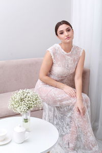 Portrait of smiling young woman sitting at home