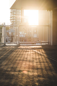 Empty street amidst buildings against sky during sunset