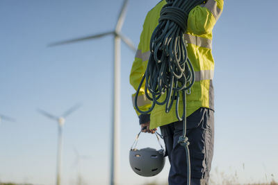 Close-up of technician at a wind farm with climbing equipment