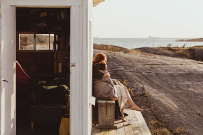 Rear view of man sitting by window