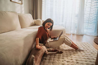 Young woman sitting on bed at home