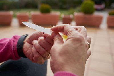 From above crop person cutting nails with clipper while doing manicure person