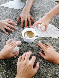 Cropped hands reaching coffee cup on road