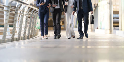Low section of people walking on floor