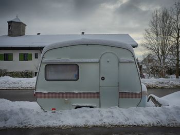 Car on snow covered landscape against sky