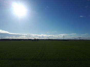 Scenic view of field against bright sun