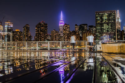 Illuminated empire state building seen from terrace in city at night