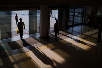 Silhouette people standing on tiled floor