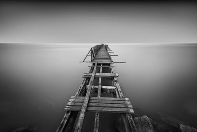 Narrow wooden jetty at calm sea