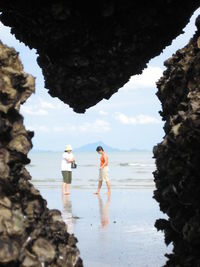 People standing at beach against sky