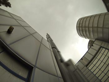 Low angle view of modern building against cloudy sky