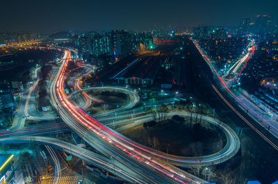 Aerial view of elevated roads in illuminated cityscape at night