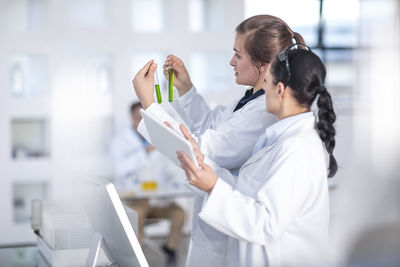 Two scientists working in lab together looking at test tubes