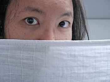Close-up portrait of a young woman hiding face