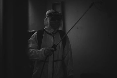 Man holding umbrella standing against black background