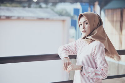 Woman wearing hijab while standing on corridor