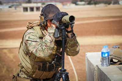 Army soldier looking through binoculars