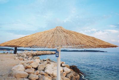 Umbrella by sea against sky