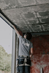 Caucasian male builder clean the window opening.