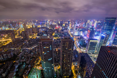 High angle view of illuminated cityscape against cloudy sky