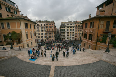 People on street in city against sky