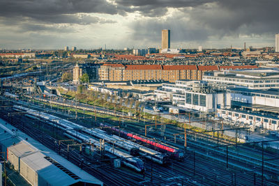 Morning view of the copenhagen city skyline from an elevated vantage point. trains in foreground.