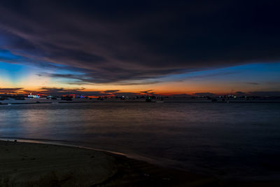 Scenic view of sea against dramatic sky during sunset