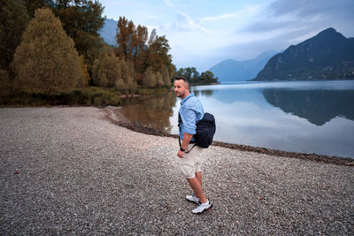 Full length of man standing at lakeshore