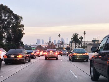 Traffic on road in city against sky