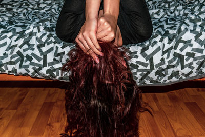 Midsection of woman relaxing on floor at home