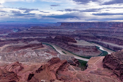 Aerial view of dramatic landscape against cloudy sky