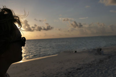 Portrait of man on beach against sky during sunset