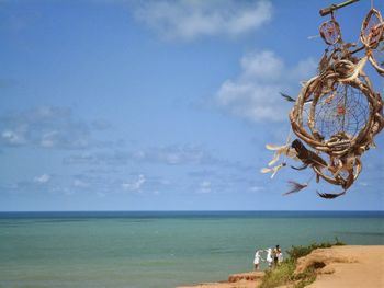 Close-up of dry dreamcatcher over sea against sky