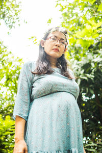 Portrait of woman standing against plants