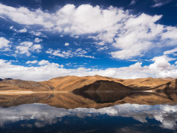 Scenic view of lake by mountains against sky