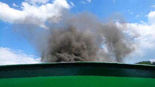 Low angle view of smoke emitting from train against sky on sunny day