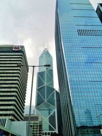 Low angle view of modern building against cloudy sky