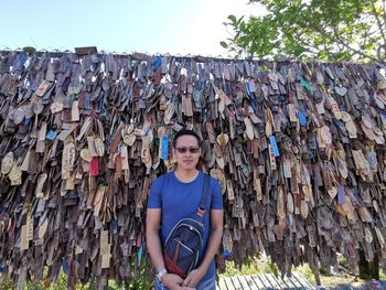 Portrait of young man standing by stack