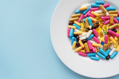 Directly above shot of pills in plate on blue background